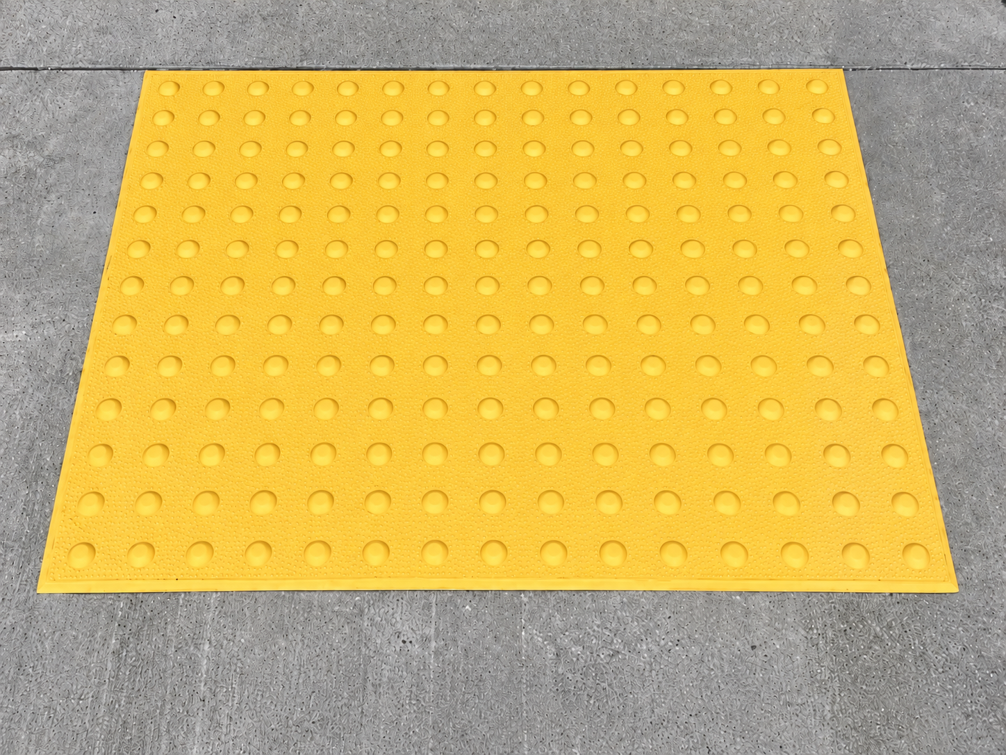 Yellow detectable warning mat laid flat
